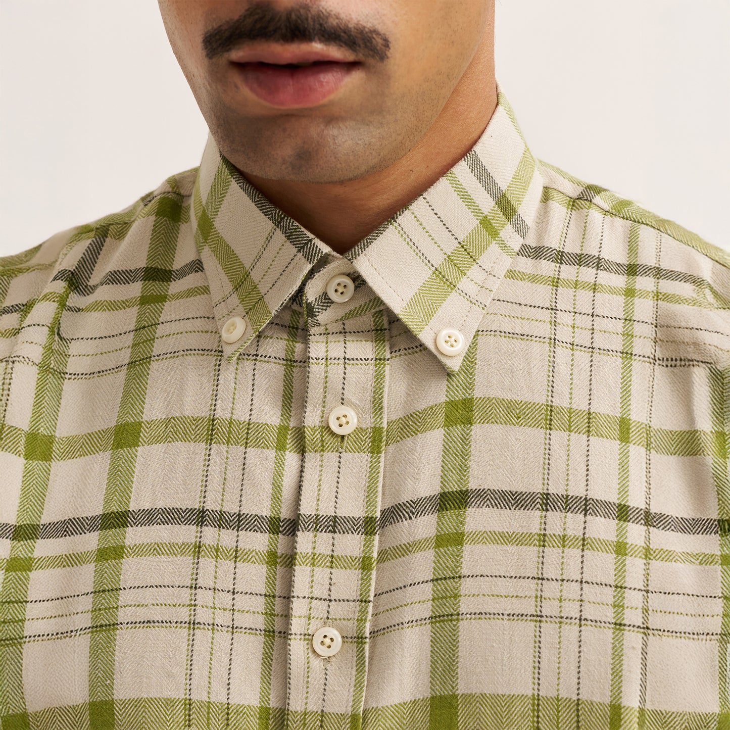 Model wearing regular fit off white and green check shirt