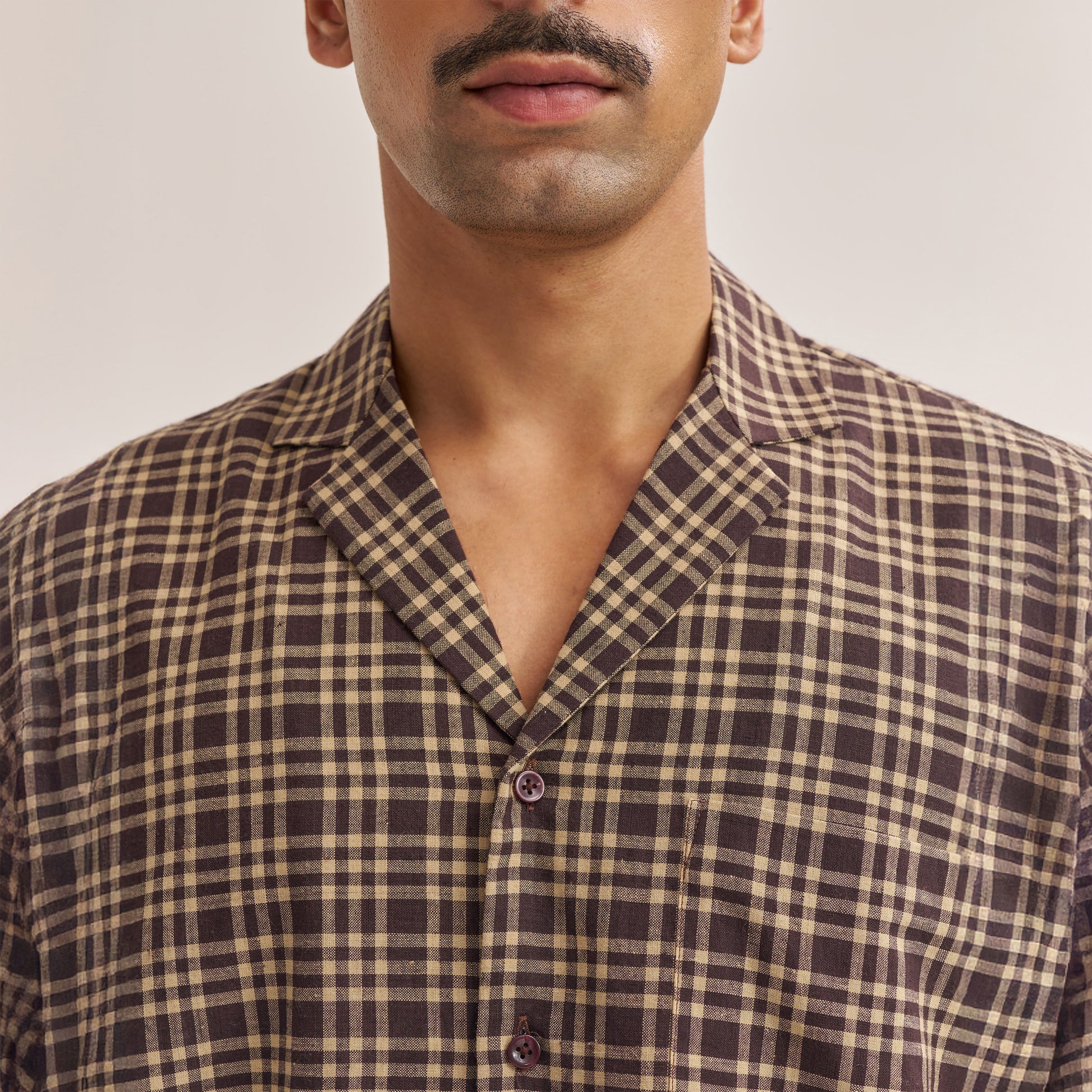 Shirt displayed on hanger showing dark brown check pattern