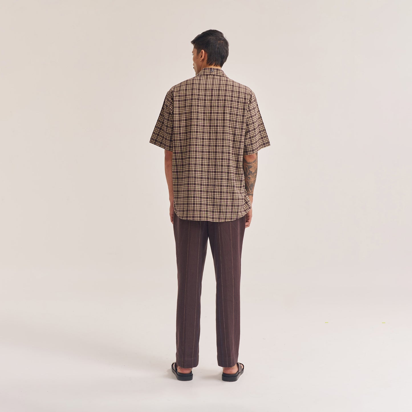 Sleeve and cuff close-up of relaxed fit dark brown check shirt
