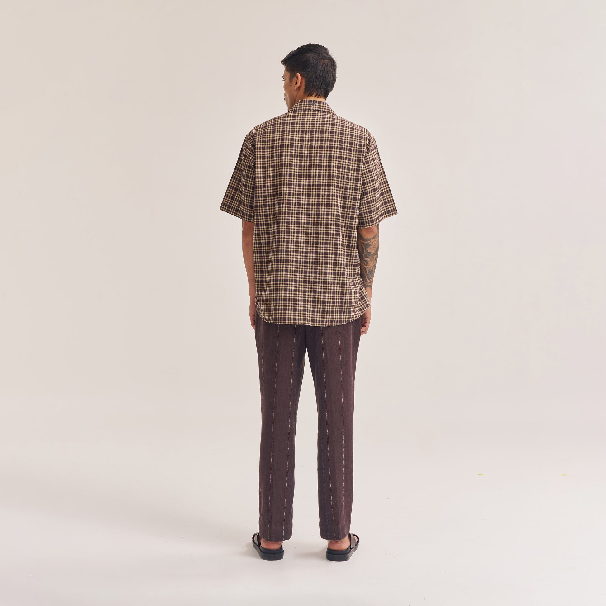 Sleeve and cuff close-up of relaxed fit dark brown check shirt